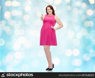 gesture, portrait and people concept - smiling happy young plus size woman posing in pink dress showing thumbs up over blue holidays lights background