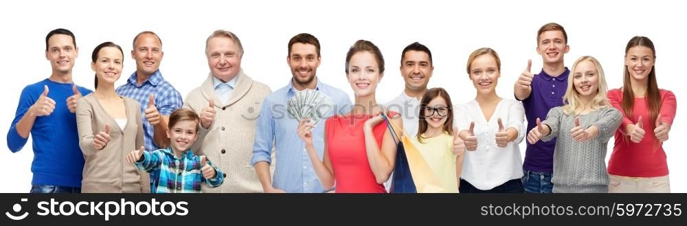 gesture, sale and people concept - group of smiling men, women and kids showing thumbs up and holding shopping bags with money