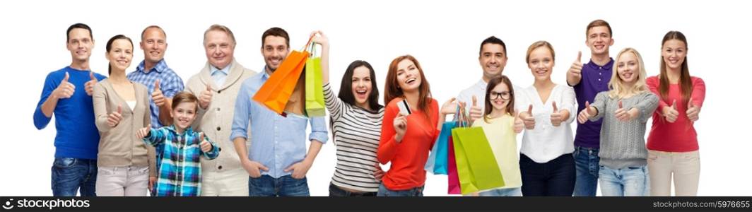 gesture, sale and people concept - group of smiling men, women and kids showing thumbs up and holding shopping bags with credit card