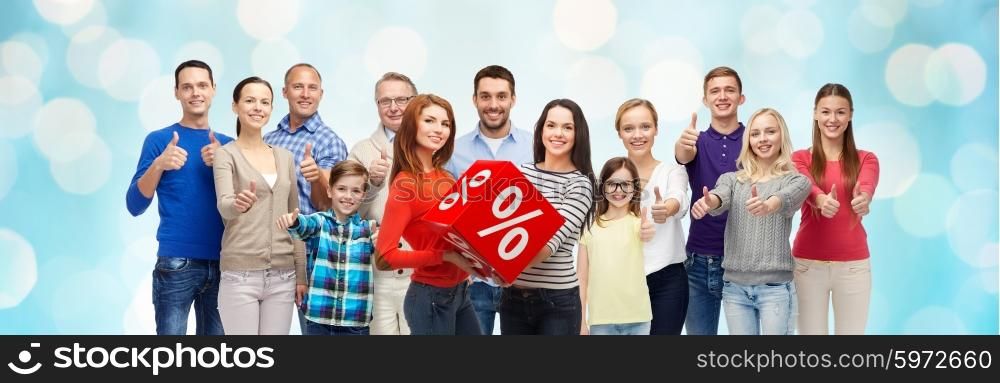 gesture, sale, shopping and people concept - group of smiling men, women and boy showing thumbs up over blue holidays lights background