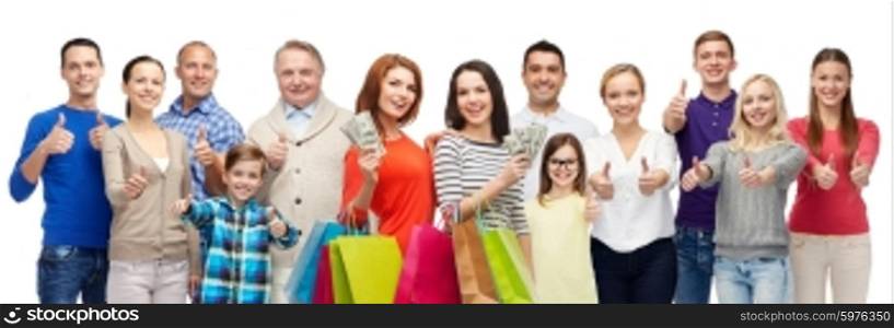 gesture, sale, shopping and people concept - group of smiling men, women and kids showing thumbs up and holding shopping bags with money
