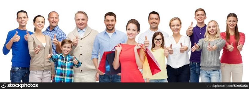 gesture, sale, shopping and people concept - group of smiling men, women and kids showing thumbs up and holding shopping bags