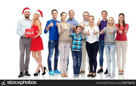 gesture, shopping, discount, christmas and people concept - group of happy people showing thumbs up and couple with sale sign