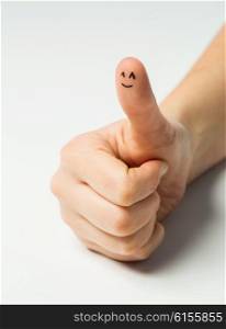 gesture, success and body parts concept - close up of woman hand showing thumbs up with smiley face