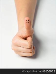 gesture, success and body parts concept - close up of woman hand showing thumbs up with smiley face