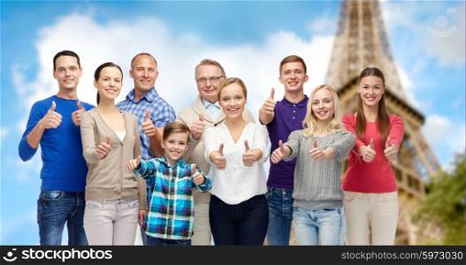 gesture, travel, tourism and people concept - happy family showing thumbs up over eiffel tower background