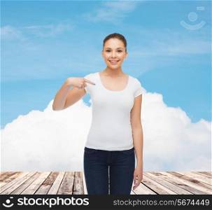 gesture, vacation, advertising and concept - smiling young woman in blank white t-shirt pointing finger on herself over wooden berth and blue sky background