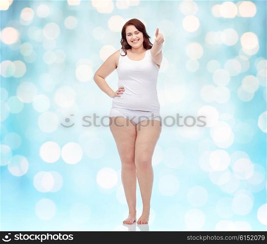 gesture, weight loss and people concept - smiling young plus size woman in underwear showing thumbs up background over blue holidays lights background