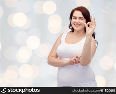 gesture, weight loss and people concept - smiling young plus size woman in underwear showing ok hand sign over holidays lights background