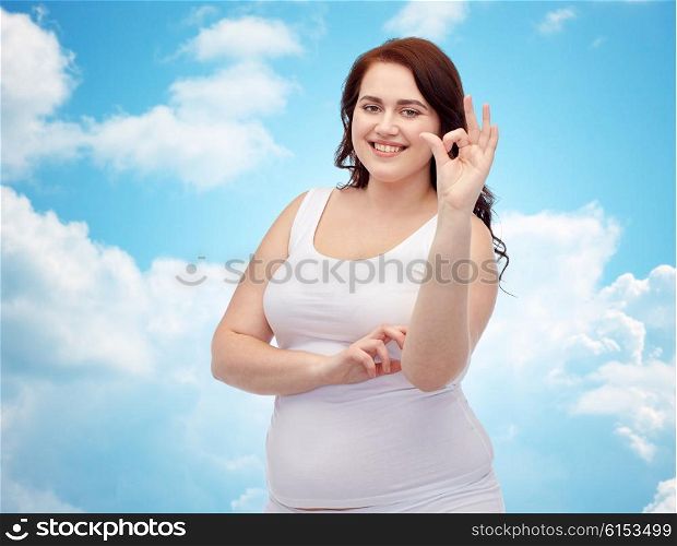 gesture, weight loss and people concept - smiling young plus size woman in underwear showing ok hand sign over blue sky and clouds background