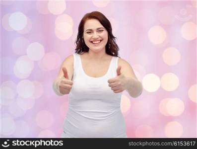gesture, weight loss and people concept - smiling young plus size woman in underwear showing thumbs up over pink holidays lights background