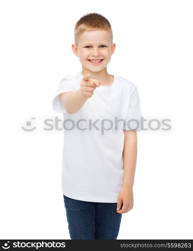 gestures, advertisement, childhood and happy people concept - happy little boy in blank white t-shirt pointing at you