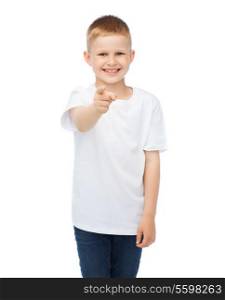 gestures, advertisement, childhood and happy people concept - happy little boy in blank white t-shirt pointing at you