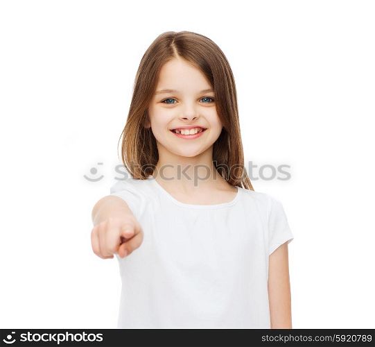 gestures and happy people concept - happy little girl in blank white t-shirt pointing at you. little girl in blank white t-shirt pointing at you