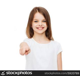 gestures and happy people concept - happy little girl in blank white t-shirt pointing at you. little girl in blank white t-shirt pointing at you