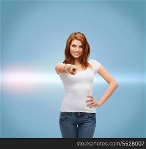 gestures and people concept - happy teenager in blank white t-shirt pointing at you