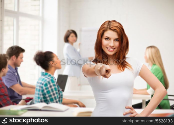 gestures, school and education concept - happy teenager at school in white t-shirt pointing at you