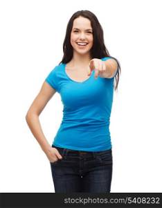 gestures, t-shirt design and people concept - happy girl in blank blue t-shirt pointing at you