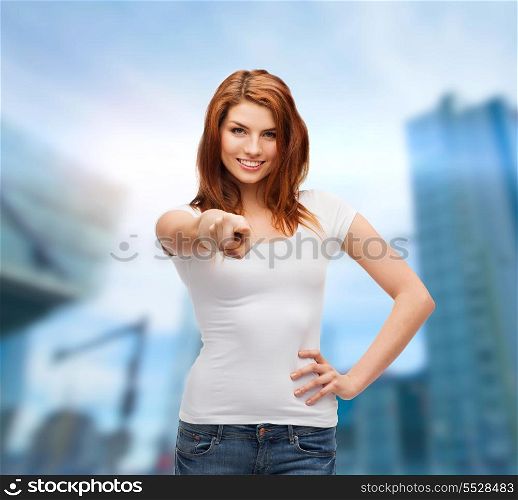 gestures, tourism, vacation and people concept - happy teenager in white t-shirt pointing at you