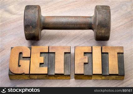Get fit - motivational word abstract in vintage letterpress wood type printing blocks with a vintage dumbbell