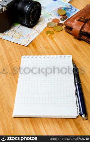 getting ready for travel, money, map and photo camera on wooden table with copy space