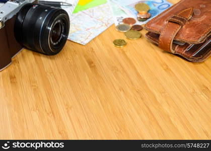 getting ready for travel, money, map and photo camera on wooden table with copy space