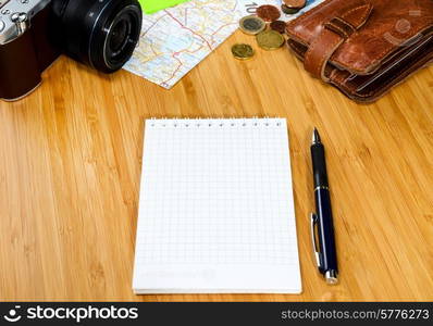 getting ready for travel, money, map and photo camera on wooden table with copy space