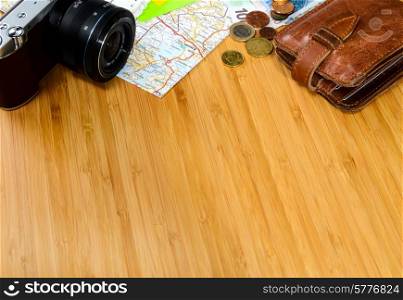 getting ready for travel, money, map and photo camera on wooden table with copy space