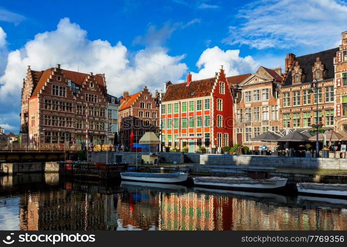 Ghent canal Graslei and Hooiaard streets with tourist boats on sunset. Ghent, Belgium. Ghent canal and Graslei street. Ghent, Belgium