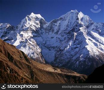 Giant mountains in the Himalaya dwarf a tiny village