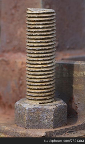 Giant rusty screw on a support of an electricity transmission. Close-up