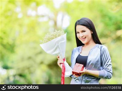 Gift box and bouquet of flowers in hand woman Asian girl beautiful smiling give a gift for Christmas and New Year festival Or valentine day concept
