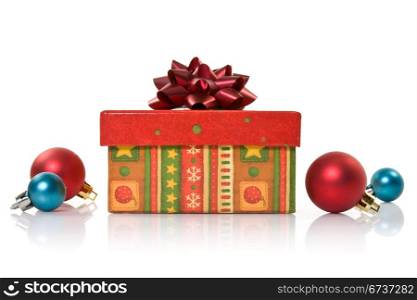 gift box and christmas baubles on white background