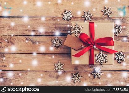 Gift box and christmas decoration with snow on wood background with space.