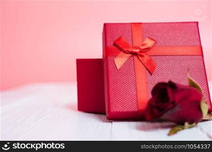 Gift box and flower roses on white wooden background, valentine day concept