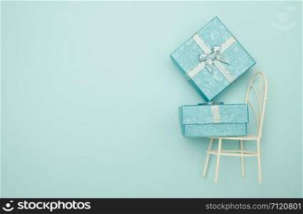 Gift box and iron chair on blue background with copy space for write, valentine concept.
