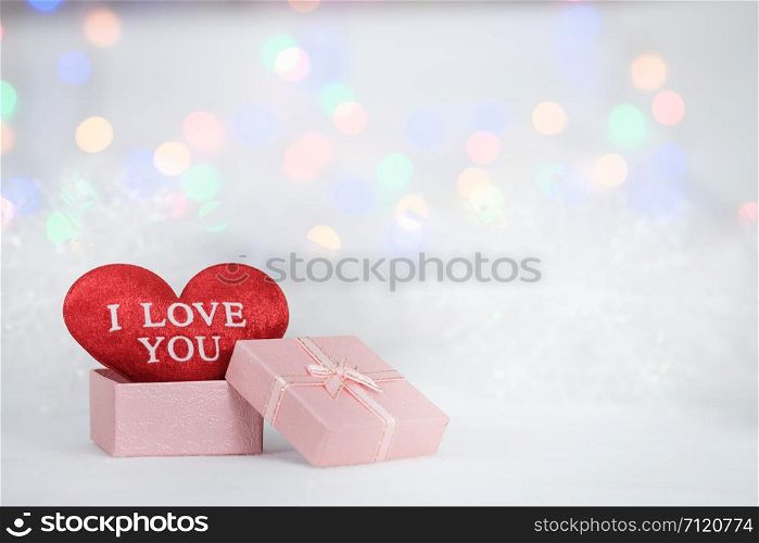 gift box and mini heart pillow on the white fur, bokeh background, with copy space for season greeting, Happy New Year, AF point selection, blurred.
