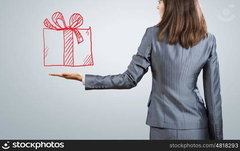 Gift box. Back view of businesswoman holding present box in hand