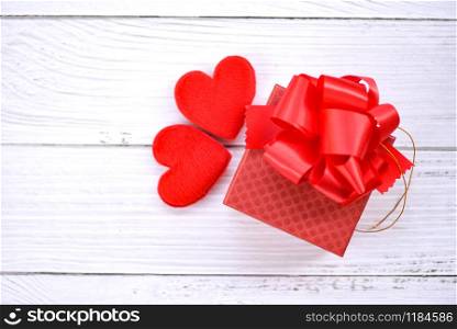 Gift box decorate with red heart on white wooden valentines day background , top view copy space