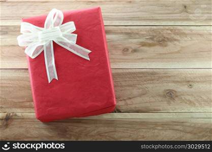 Gift box is placed on wooden floor.. Gift box is placed on wooden floor in concept of Christmas and New Year.