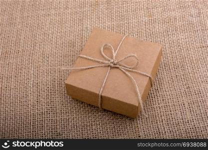 Gift box of brown color on linen canvas