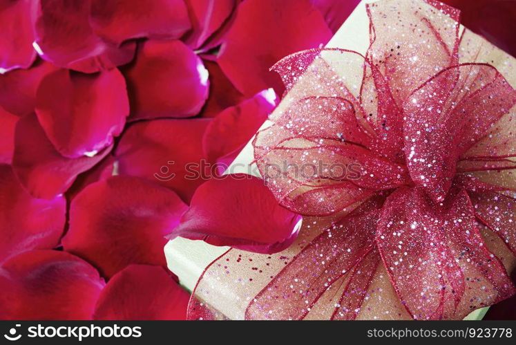 Gift box on red rose petals background