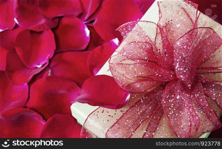 Gift box on red rose petals background