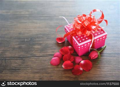 Gift Box pink with roses petals flower romantic for gift Valentines day on wooden rustic texture background top view