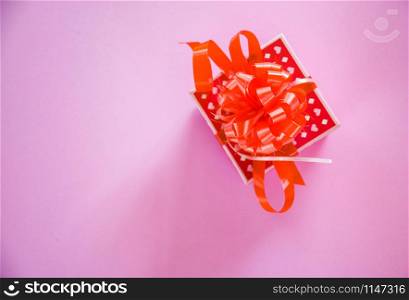 Gift Box red Valentines day concept / Red present box with ribbon bow on pink background