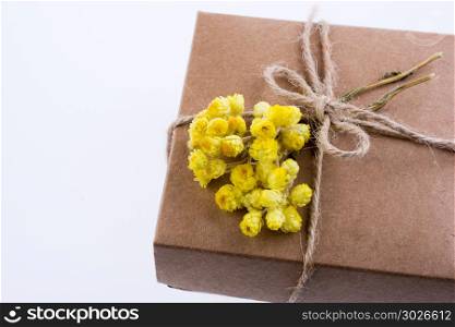 Gift Box with Flowers. Wrapped gift box with yellow flower on white background