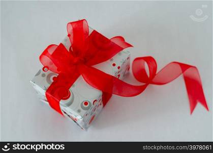 Gift box with red ribbon and bow on white background