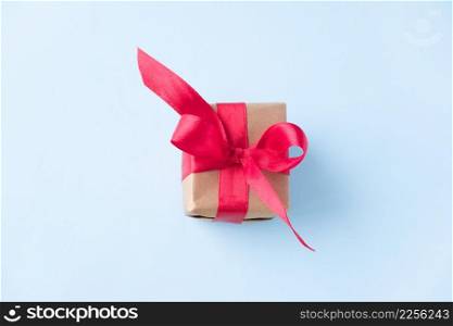 Gift box with red ribbon on blue background. zero gravity. levitation. milimalism. Concept sales, shopping, christmas holidays and birthday.. Gift box with red ribbon on blue background. zero gravity. levitation. milimalism. Concept sales, shopping, christmas holidays and birthday