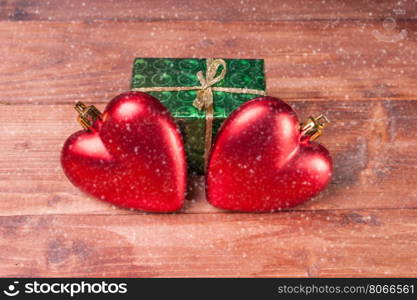 Gift box with two red hearts - Christmas decorations on wooden background. Gift box with two red hearts on wooden background. Greeting background