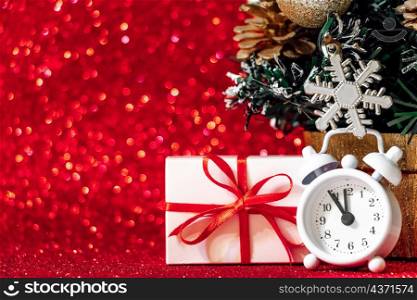 Gift boxes and alarm clock on a red glittering background. Christmas concept, place for text.. Gift boxes and alarm clock on a red glittering background. Christmas concept